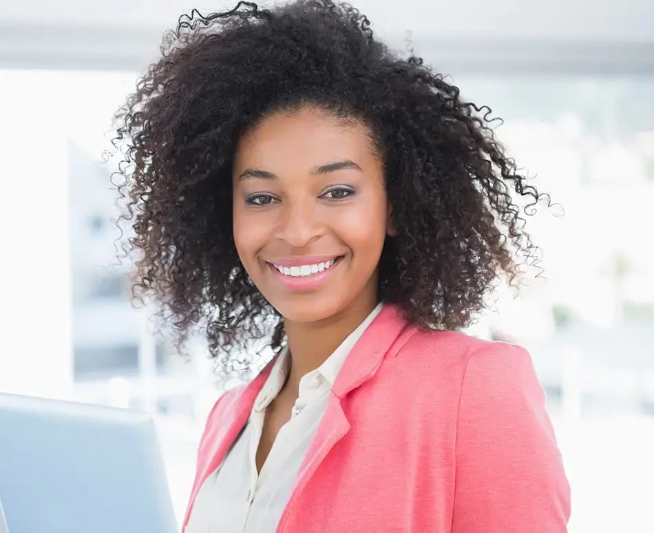 Happy smiling business woman at her office after installing Bullhorn software and integrating it with Sage Intacct