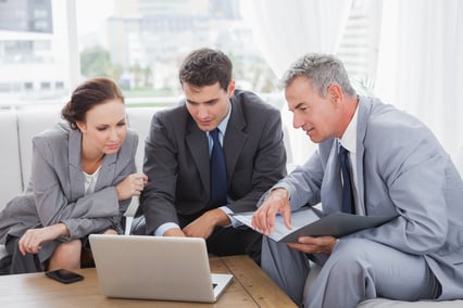 Business people working together on their laptop in cosy meeting room