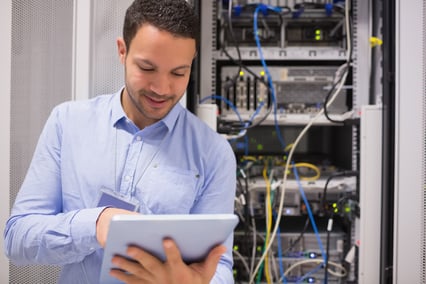 Data centre worker with tablet computer in data centre