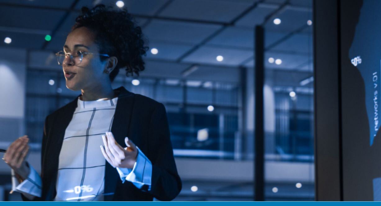 worker in a dark office looking at a screen
