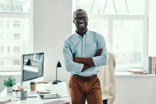 Businessman smiling at camera with arms folded, happy with his Bullhorn integration