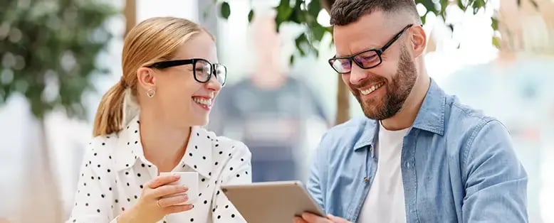 2 smiling business people look at their Hubspot data from their integration with Saltbox