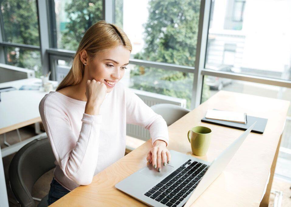 Smiling businesswoman works on a laptop