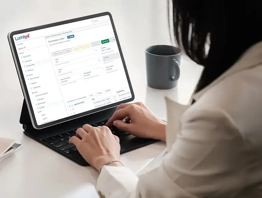 Businesswoman uses a laptop with Lumiya purchasing and invoice automation screenshot on her laptop