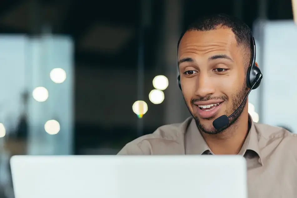 Man at computer with headset ready to help with your Sage Intacct Success