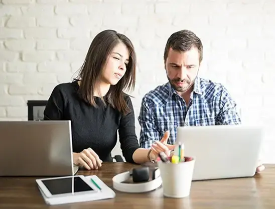 Colleagues work together on laptops to show Saltbox’s pre-built workflows and custom automation for the recruitment industry